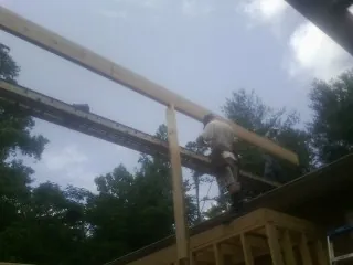 Carpenter setting a ridge beam over a new addition frame — Ice Dam Removal by Roofing Brothers in Stout